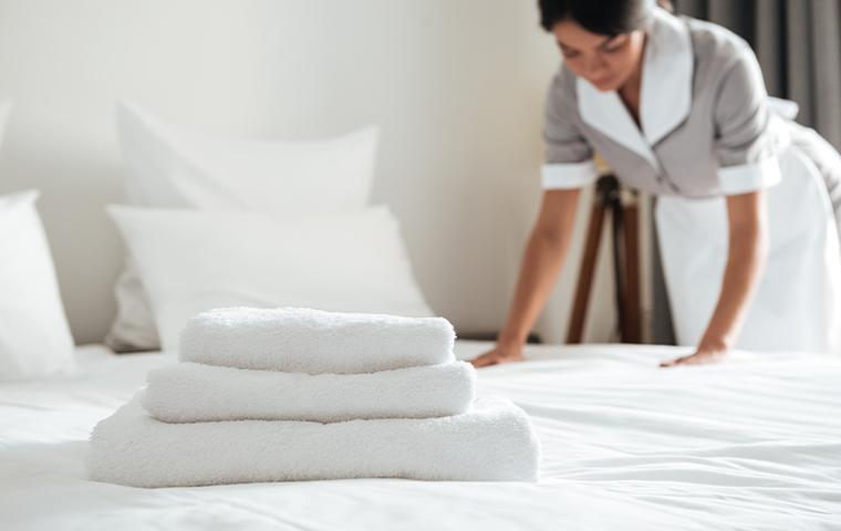 maid making up hotel bed