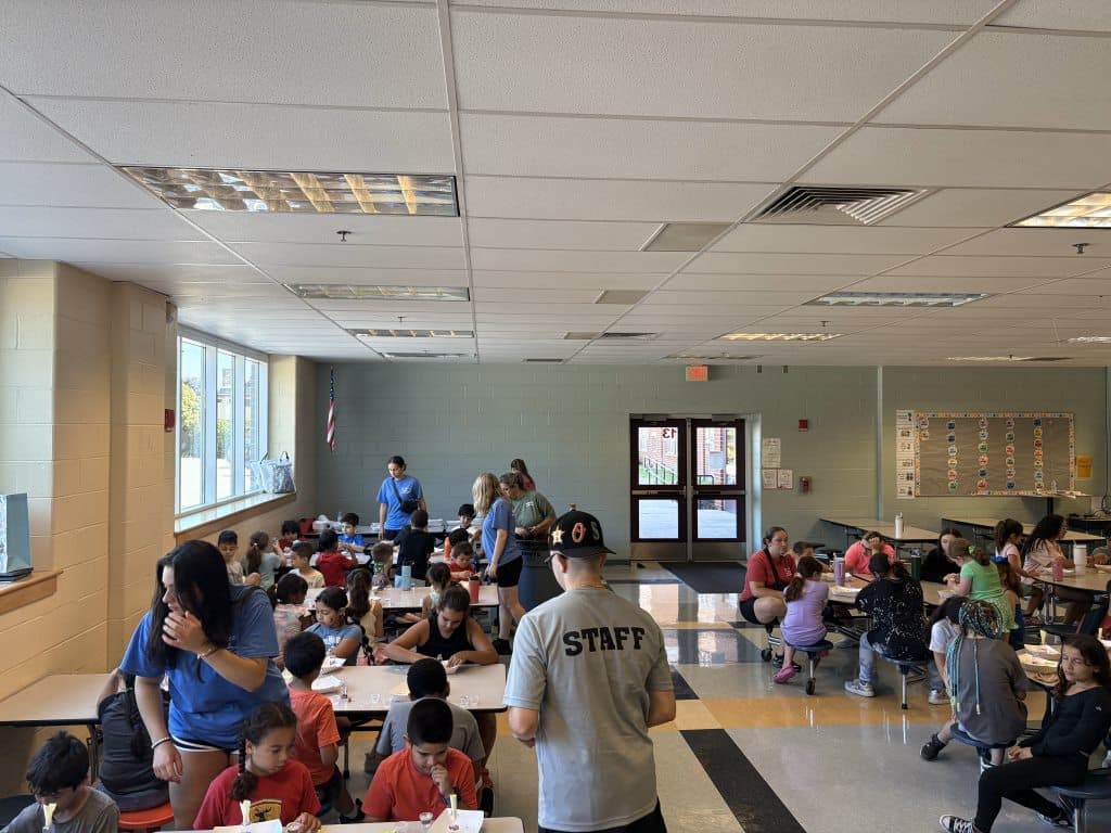 Children and Staff sitting and standing at tables