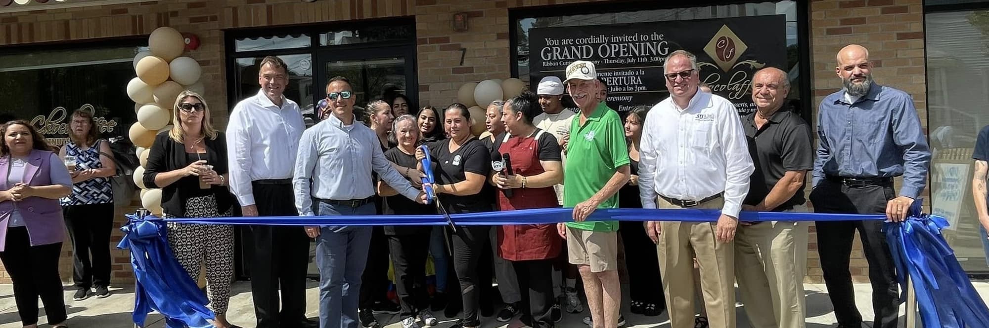 Group of people cutting a ceremony ribbon