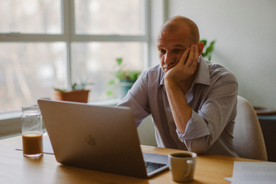 Tired man sitting at a desk experiencing daytime fatigue and brain fog associated with sleep apnea
