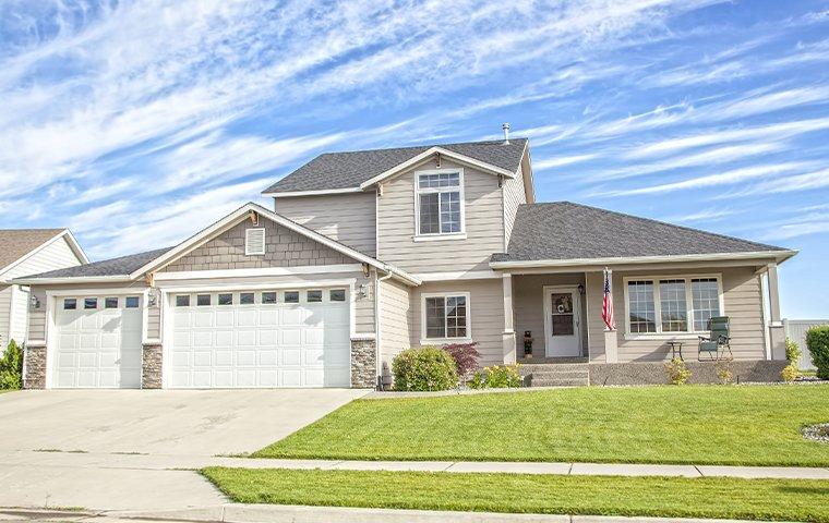a gray two story house with attached garage