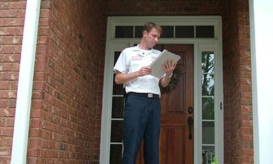 tech outside house inspecting