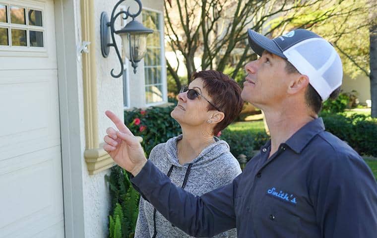 Helpful Pest & Wildlife Articles pest control technician looking at home with customer