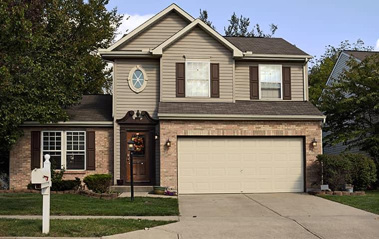 a tan two story house with attached garage