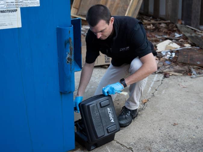 Learn More About Our Process For Controlling Rodents Around Your New Jersey Home tech inspecting rodent station for signs of mice or rats.