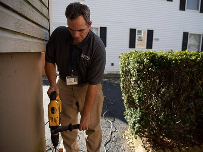 Learn More About Our Pre-Treatment Options For Targeting Termites drilling holes in foundation for termite treatment around new jersey home