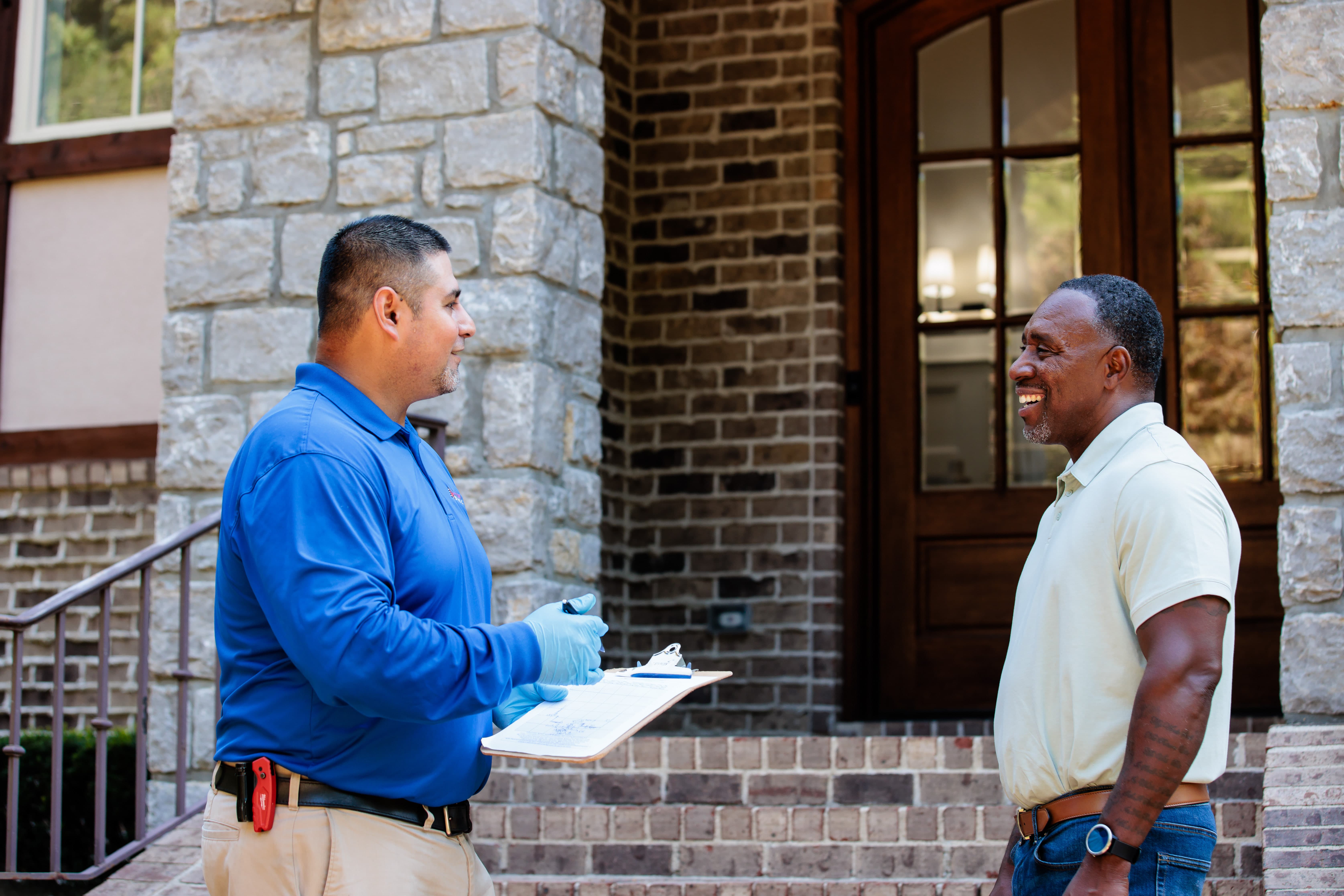 All-American Pest Control employee talking to customer on porch
