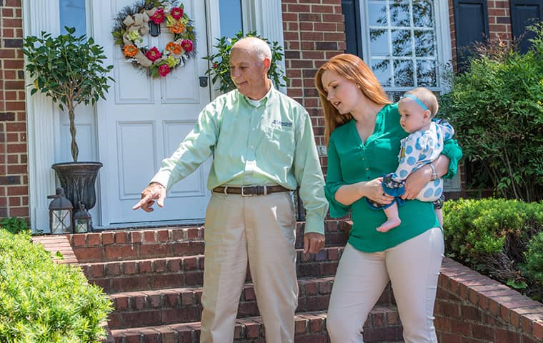 Learn More About Home Pest Control In Murfreesboro TN all american tech explaining services to a client outside of her murfreesboro tennessee home